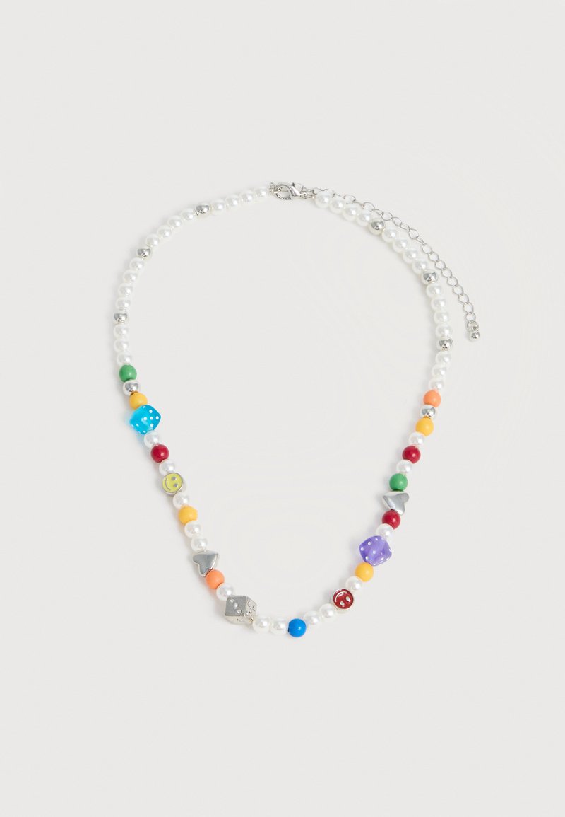 Κολιέ με λευκές πέρλες, πολύχρωμες χάντρες, ασημένια καρδιά και ζάρια ως γούρια, και ασημένια αλυσίδα κούμπωμα σε λευκό φόντο.