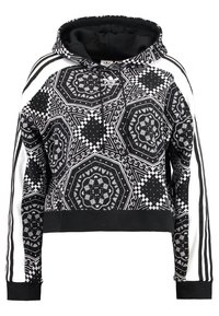 Černobílá zkrácená mikina s kapucí s propracovaným geometrickým vzorem, kapucí na stahovací šňůrku a kontrastními bílými pruhy na rukávech.