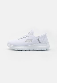 White athletic shoes with a mesh upper, textured accents, and a flexible rubber sole. Features a prominent logo on the side.