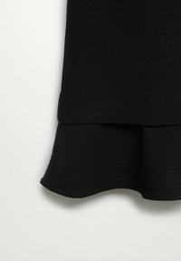 Jupe en tissu noir avec un ourlet évasé, une texture lisse et des détails de couture visibles le long du bord inférieur. Design simple et uni.