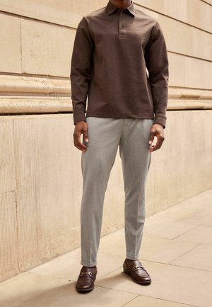 Brown long-sleeve polo shirt, light gray tailored pants, and brown loafers with a gold buckle detail. Flat texture, classic fit, neutral tones.
