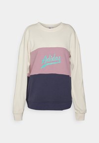 Sudadera Adidas de manga larga con bloques de color crema, rosa y azul marino, con el logo en forma de guion de Adidas en turquesa en el pecho.