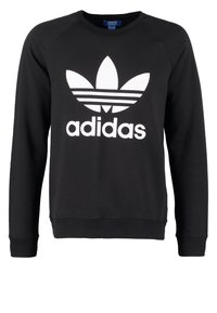 Svart sweatshirt med rund halsringning, ribbade ärmslut och nederkant. Har en stor vit Adidas-logotyp med en bladliknande grafik ovanför varumärket.