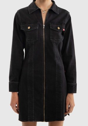 Mustasta denimistä valmistettu pitkähihaiset mekko, jossa edessä vetoketju, kaksi nappisuljettavaa rintataskua ja kaulus, päällä helmikoristeinen simpukkakaulakoru.