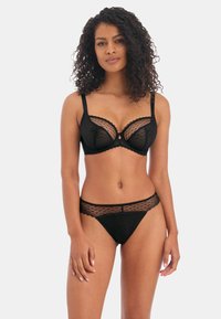 Black lingerie set featuring a sheer lace bra with scalloped edges and a matching thong with a textured band. Both items are delicate and feminine.