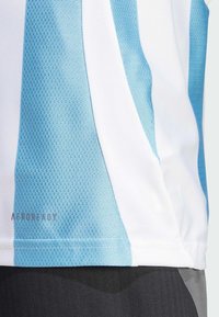 Maillot de sport léger avec des rayures verticales bleu clair et blanches. Tissu texturé avec le logo 'AEROREADY' près de l'ourlet.