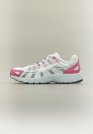 Baskets de sport blanches et grises avec accents roses, empeigne en mesh, semelle rembourrée et lacets, vues de profil sur un fond neutre.