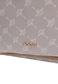 Bolso de mano sintético gris con una superficie texturizada, que presenta un patrón floral repetido y un logo dorado "JOOP!" en la parte delantera.