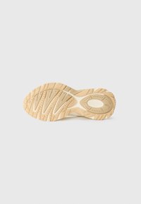 Lacoste sneaker zool, met een gestructureerde rubberen zool met een zigzagpatroon, in een lichte tan kleur en met een reliëflogo.