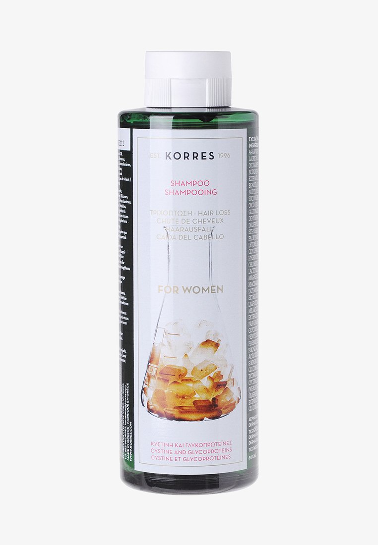 Grüne Kunststoff-Shampoo-Flasche mit einem weißen Deckel. Das Etikett zeigt einen Laborfluss mit gelb-orangefarbenen Steinen, der Text ist in mehreren Sprachen verfasst.