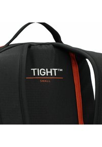 Mochila negra con tejido acolchado, presenta un acento naranja y la marca "TIGHT™ SMALL" en letras blancas. Incluye correas para los hombros ajustables.