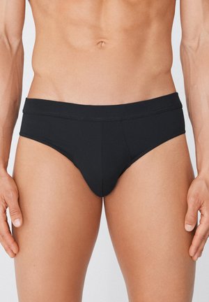 Schwarze Schwimmshorts aus dehnbarem Material mit niedrigem Bund, glatter Textur und minimalistischer Gestaltung ohne Muster oder Verzierungen.