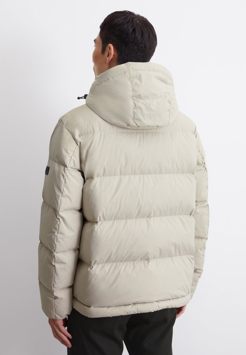 Beige Pufferjacke mit abnehmbarem Kapuzen, gestepptem Design und elastischen Bündchen. Verfügt über ein Logo-Patch am Ärmel.