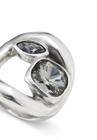 Bague en argent avec deux pierres facettées : une grise et une transparente, montées dans un design organique lisse avec une finition polie.