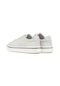 Sneaker in pelle grigia con una texture liscia, forma arrotondata, suola bianca piatta e dettagli metallici attorno al midsole.