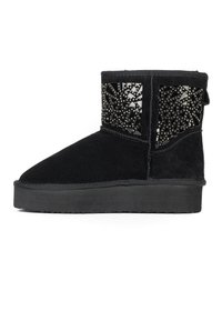 Botines de ante negros con un diseño texturizado en la parte superior que presenta un corte decorado con tachuelas metálicas. Suela de goma gruesa y punta redondeada.