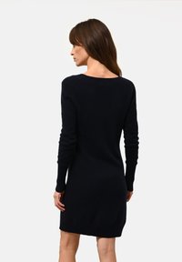 Námořnické pletené šaty ve stylu svetr s lodičkovým výstřihem, dlouhými rukávy a žebrovanými manžetami. Měkká textura, délka až k bokům a přiléhavý silueta.