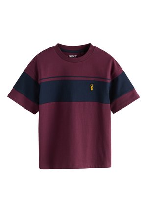 T-shirt bordeaux a manica corta con una striscia orizzontale blu navy sul petto e un piccolo emblema giallo di cervo sul lato sinistro.