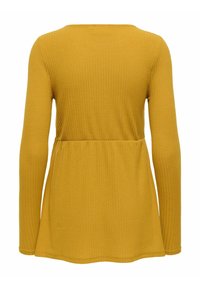 Senapsgul långärmad topp i ribbad textur, med en avslappnad passform, rund halslinje och utsvängd midja. Inga synliga mönster eller accenter.