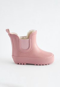 Bottine en caoutchouc rose avec semelle texturée et panneau latéral élastique, dotée d'une doublure intérieure douce, duveteuse couleur crème.