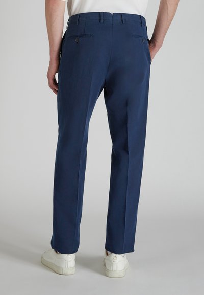 Granatowe spodnie o prostym kroju, materiał wygląda na gładki, z dwiema tylnymi kieszeniami z guzikami oraz szlufkami na pasek.