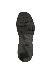 Black sneaker outsole with textured rubber for grip, featuring varied tread patterns and a smooth design, highlighting durability and traction.