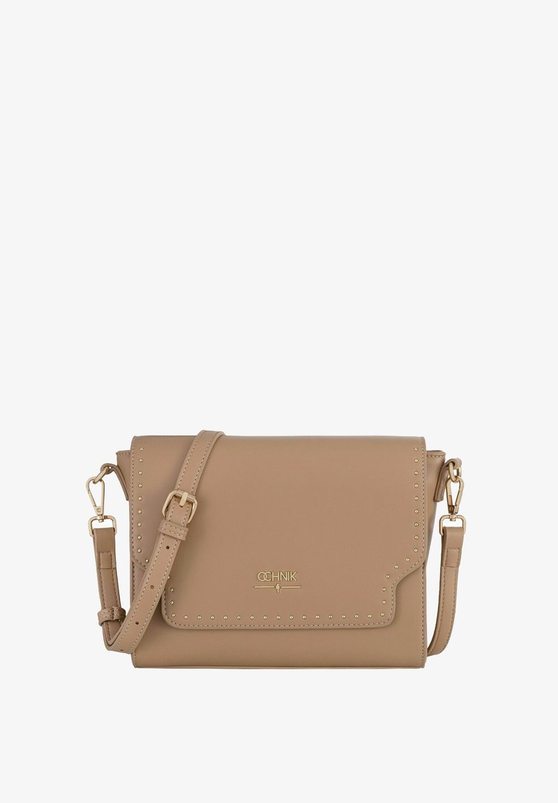 Beżowa torebka crossbody z syntetycznej skóry z klapką, złotymi ćwiekami wzdłuż krawędzi oraz odpinanym paskiem. Na przedniej części znajduje się złote logo.