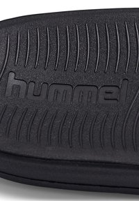 Talpă interioară din cauciuc negru, cu textură striată și logo-ul "hummel" embosat. Dispune de o formă conturată pentru confort.