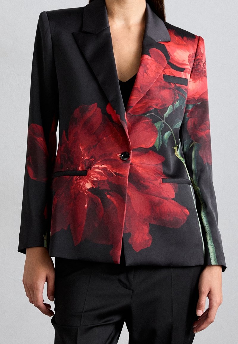 Schwarzes Blazer mit großem rotem Blumenmuster, Ein-Knopf-Verschluss, scharfen Revers und seitlichen Taschen. Glatte Textur und taillierte Passform.