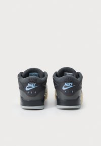 Sorte og grå Nike sneakers med lyseblåt logo, tekstureret hæl, polstret krave og gummisål. Visuel branding på hælpanelet.