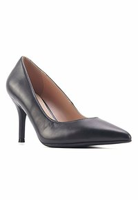 Escarpin noir en cuir verni à talon haut avec un bout pointu, texture lisse et un talon fin. L'intérieur présente une doublure de couleur claire.