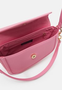 Sac bandoulière rose texturé avec rabat ouvert, poche intérieure zippée et bandoulière amovible avec ferrures dorées.