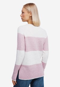 Maglione a righe bianco e rosa chiaro, realizzato in tessuto morbido. Presenta un orlo a costine e spacchi laterali per un comfort e uno stile extra.
