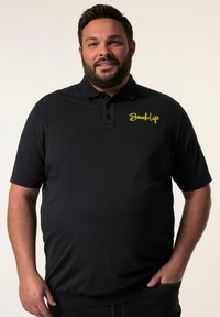 Černé polo tričko s jednolitou texturou, vybavené léga na tři knoflíky a logem "BeachLife" v žluté barvě na levé části hrudníku. Jednoduchý design.