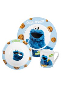 Ceramic dishware set featuring Cookie Monster. Blue color, fuzzy texture graphic. Includes a plate, bowl, and mug with cookie patterns.