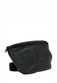 Borsa a vita nera realizzata in tessuto resistente, con chiusura a zip, superficie testurizzata e una toppa rettangolare con il nome del marchio.