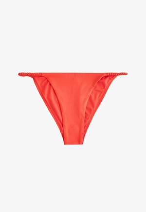 Élénk narancssárga bikini alsó fonott oldalpántokkal, fehér háttér előtt lefektetve.