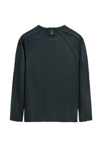 Camicetta a maniche lunghe di un verde scuro, con scollatura tonda e maniche raglan. Tessuto morbido e dalla consistenza particolare, con un piccolo logo nella parte posteriore del collo.