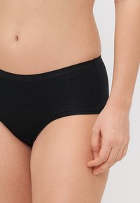Black cotton hipster underwear with a smooth texture and elastic waistband, featuring a simple, unadorned design.