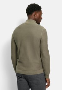 Helle olivgrüne, strukturierte Pullover mit einem gerippten Design, einem Kragen und enganliegenden Manschetten. Glattes Material und ein gerader Saum.