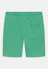 Green elastic waist shorts with a single back pocket on the right side, made of soft knit fabric.