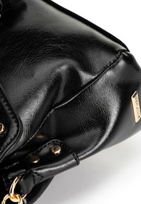 Borsa a tracolla in pelle sintetica nera con finitura testurizzata, dotata di hardware dorato, pieghe sottili e un tocco metallico con logo.