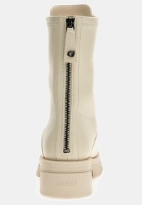 Beige leather ankle boots with a textured finish, featuring a long black zipper at the back and a chunky sole with embossed branding.