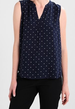 Navy blue sleeveless blouse with a v-neckline, featuring a star pattern in white. Soft, lightweight fabric with a relaxed fit.