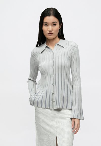 Gray ribbed long-sleeve button-up shirt with a collar; features vertical stripes and a flared cuff design. Smooth, lightweight texture.