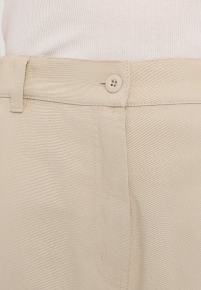 Beige housut, jotka on valmistettu puuvillasekoitteesta, suorahkot ja napilla suljettavat, ja kankaassa on hillitty vinoraitakuvio.