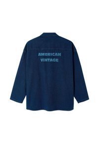 Temno modra srajca z dolgimi rokavi, na hrbtni strani z velikim napisom "AMERICAN VINTAGE" v svetlo modrih črkah.