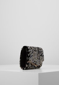 Černá vyšívaná psaníčko s zlatými a stříbrnými květinovými vzory, texturovaným povrchem a zlatým hardwarovým akcentem.