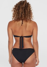 Zwarte bikini met een haltertop met striksluiting op de rug en hoge taille broekjes. Glad textuur, minimalistisch ontwerp.