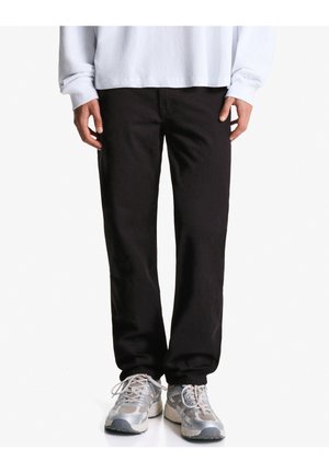 Pantaloni negri din bumbac cu un design drept. Asortați cu adidași gri deschis, care au detalii din plasă și texturi.